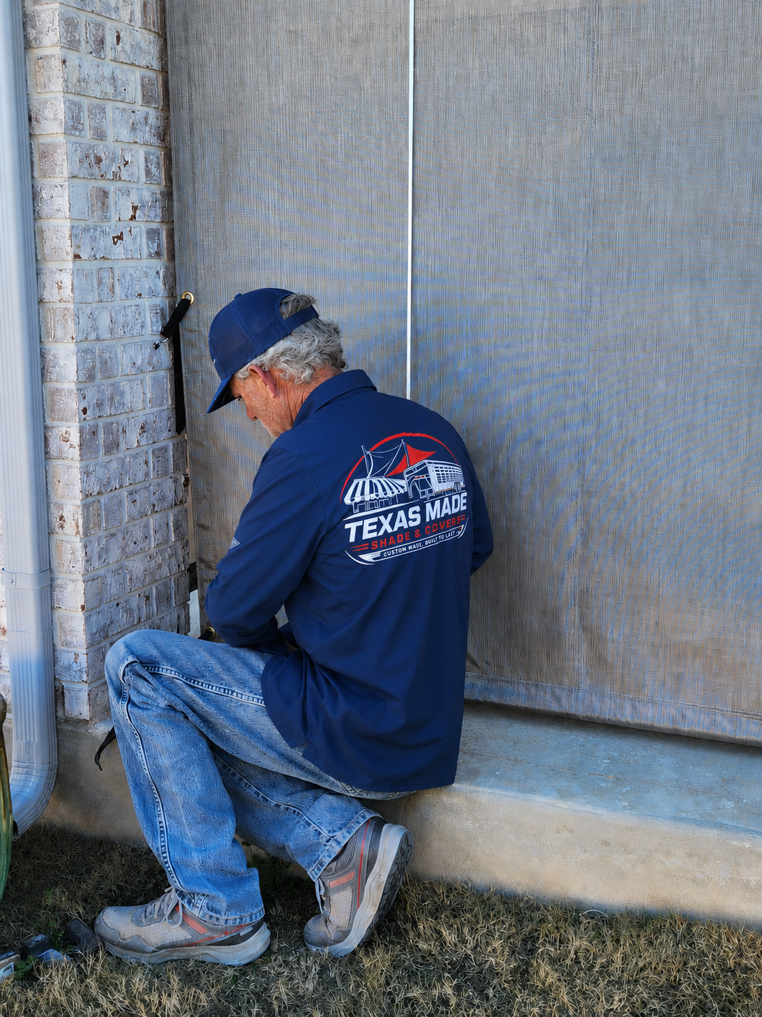 Texas Made Shade & Covers installer fitting a custom solar screen on a Texas home