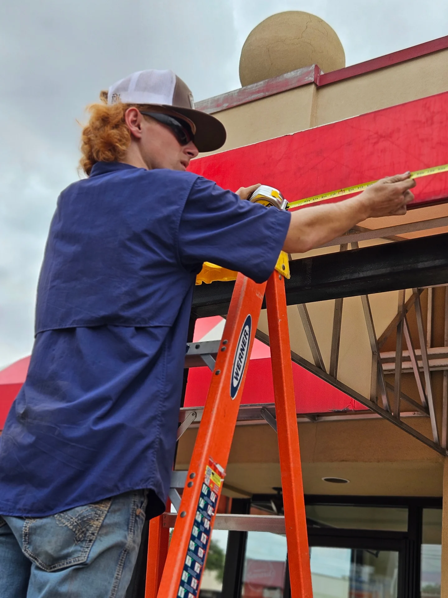 Texas Made Shade technician measuring an awning frame during a Ranger Care inspection