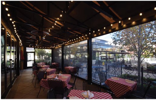Bistro patio with string lights and Solair® Power Screens dropped along the open side
