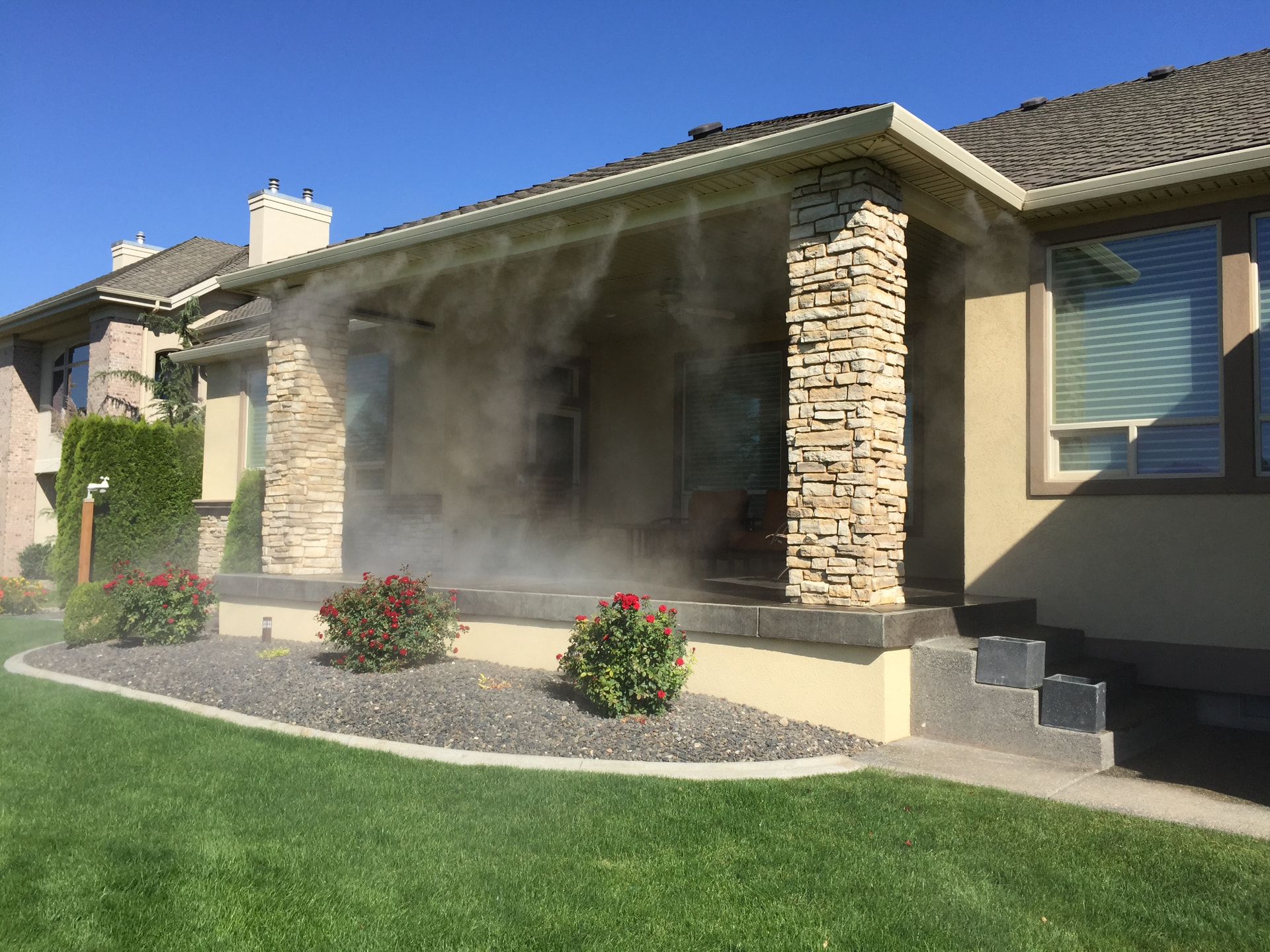 Residential covered patio misting system between stone columns on a New Braunfels, Texas home