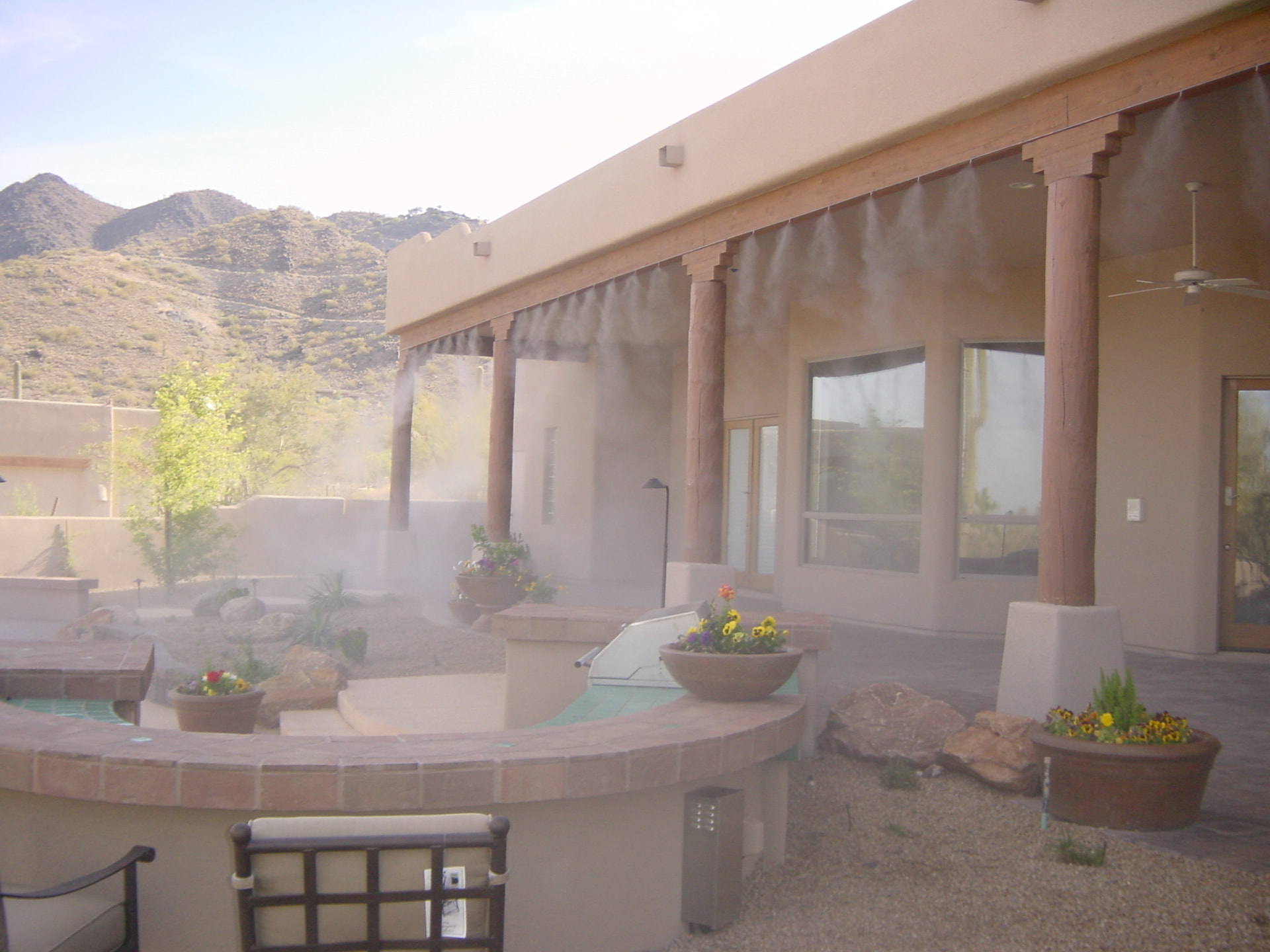 Hill Country patio misting line spraying over a hot tub and pool courtyard near Boerne, Texas