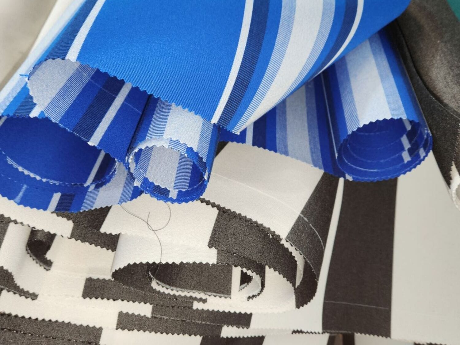 Blue striped Sunbrella awning fabric rolls staged for a custom storefront awning build
