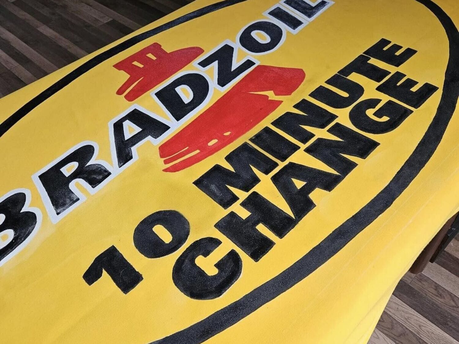 Hand-painted Bradzoil 10 Minute Oil Change commercial banner awning fabricated and installed by Texas Made Shade