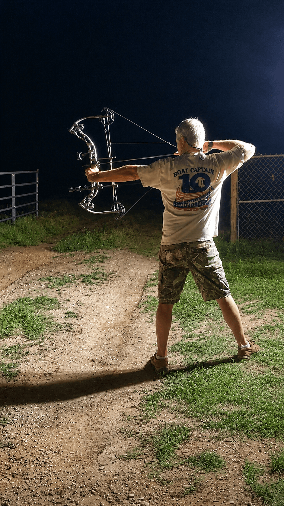 Bowhunter at full draw at night on a Texas range — Texas Made Shade hunting customer