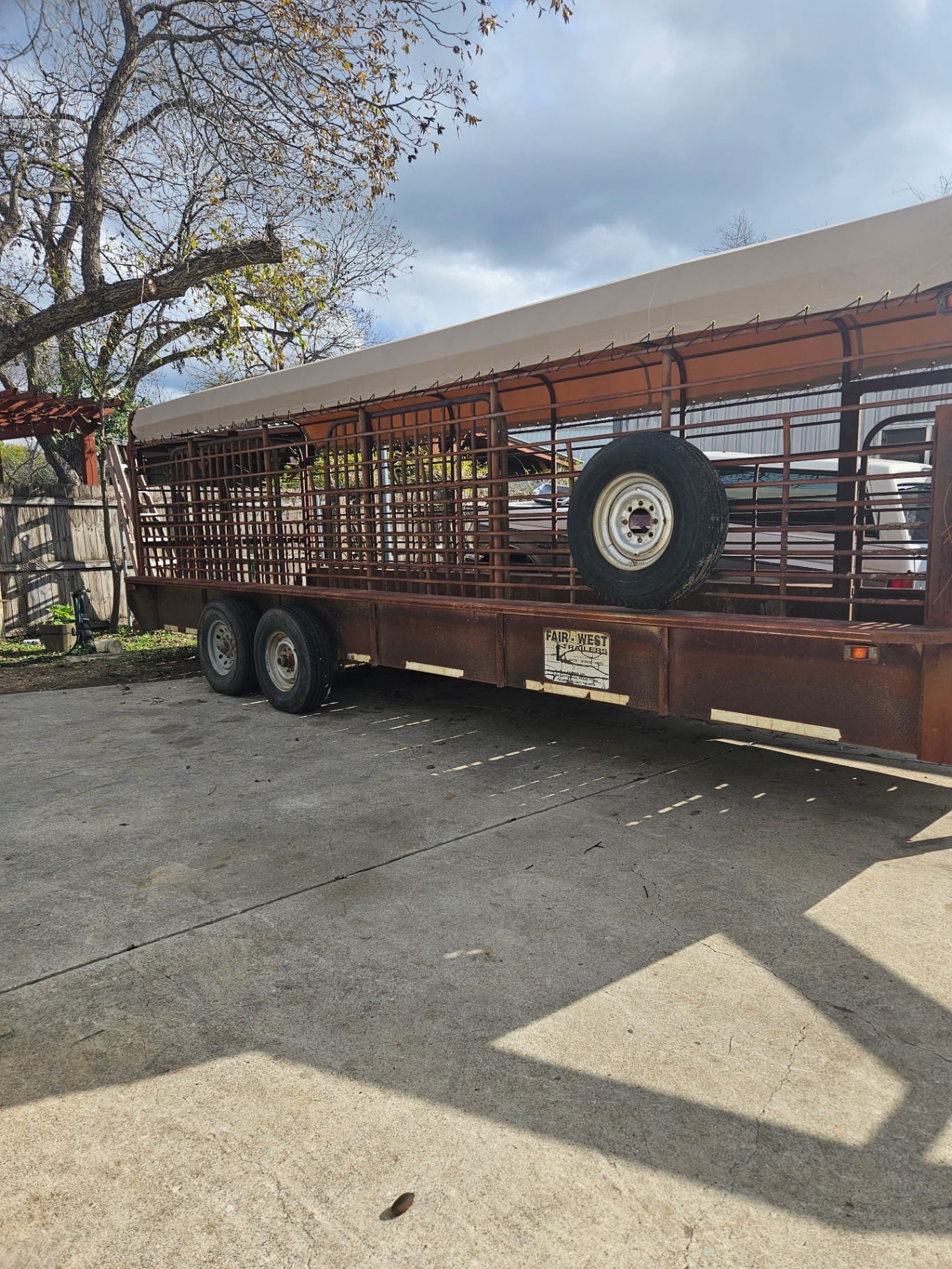 White 18oz vinyl top tarp custom-fit to a Fair-West gooseneck stock trailer with spare-tire mount, built by Texas Made Shade in Seguin